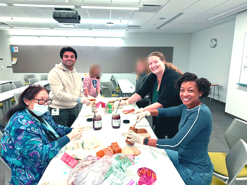 Faculty, trainees, and youth volunteers preparing meals together for community distribution
