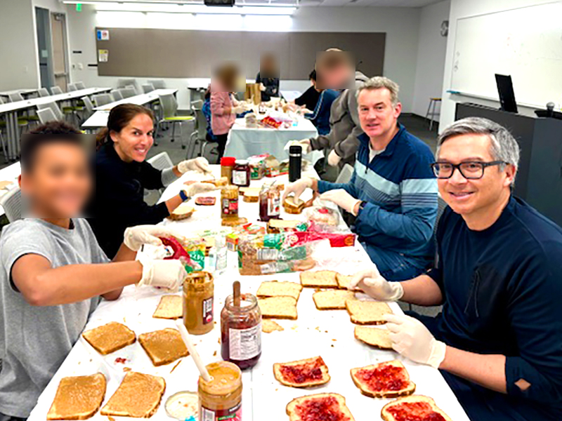 Faculty and volunteers working together to assemble meals