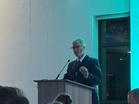 J Lotz speaking at a podium
